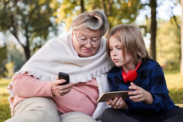 Abuela mostrando algo en su viejo teléfono —  Fotos de Stock