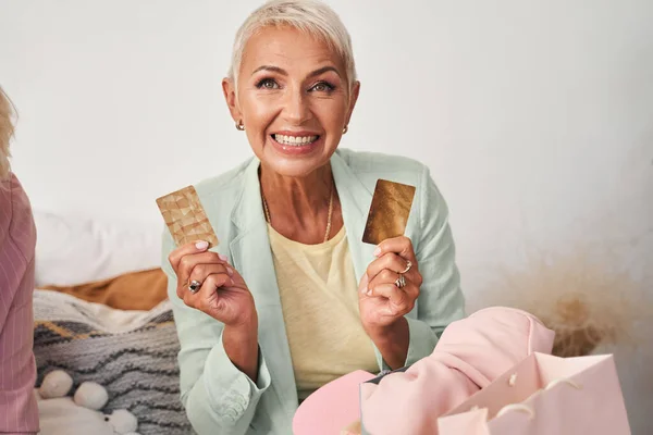 Mujer sosteniendo dos tarjetas de oro — Foto de Stock