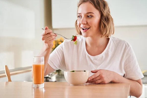 Женщина пробует свежий салат — стоковое фото