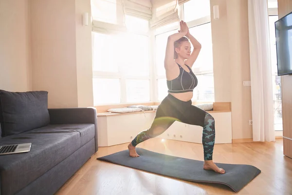 Mujer practicando yoga en pose guerrera — Foto de Stock