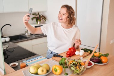 Kız mutfaktayken selfie çekiyor.