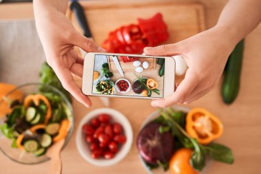 Kadın akıllı telefonuyla fotoğraf çekiyor.