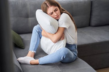 Üzgün kız yastığı tutuyor