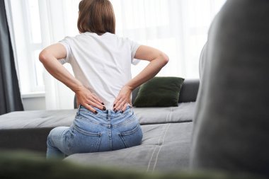 Sırt ağrısı hisseden bir kadın.