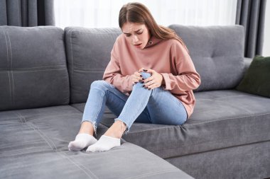 Dişi, yaralı dizine dokunuyor.