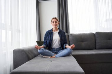 Sıcak oturma odasında meditasyon yapan bir kadın.