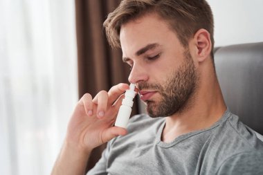 Burun spreyi olan adam.