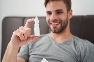 Burun damlalarına sevinçle bakan tatmin olmuş bir adam.