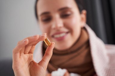 Doğum kontrol hapına bakan kadın gülümsedi.