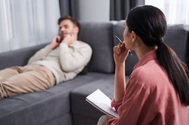 Kadın psikoterapist hastasını dinliyor.