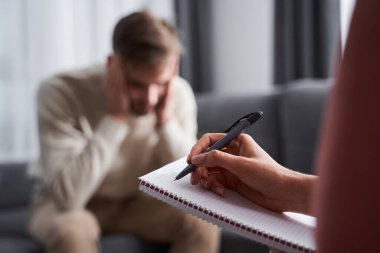 Depresyonda olan bir adam psikoterapistiyle oturuyor.