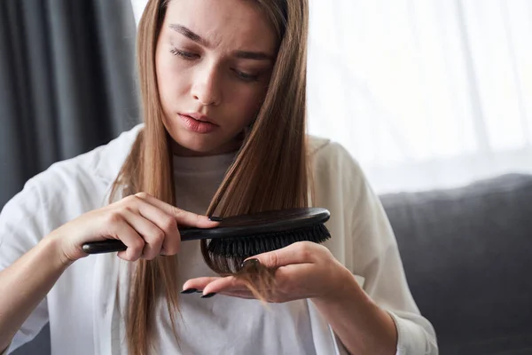 Woman looking at damaged hair tips — Stock Photo, Image