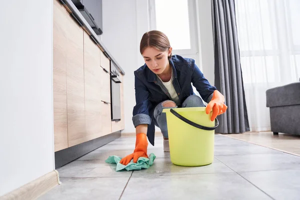 Donna pulire con cura il pavimento — Foto Stock