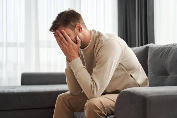 Trauriger Mann sitzt auf dem Sofa — Stockfoto