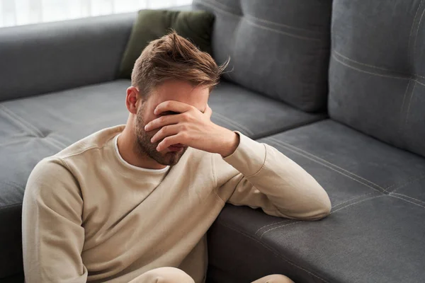 Mannen som sitter och täcker sitt ansikte — Stockfoto