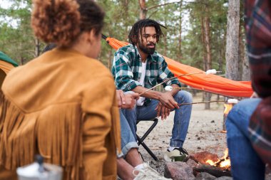 Arkadaşlar ateşte marşmelov kızartıyor.