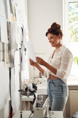 Kadın bitmiş çizimlerini inceliyor.