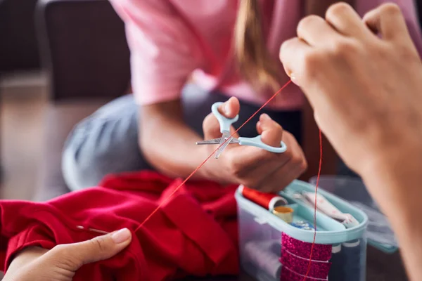 Filha cortando o fio com tesoura — Fotografia de Stock