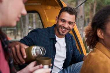 Adam bardağa çay dolduruyor.