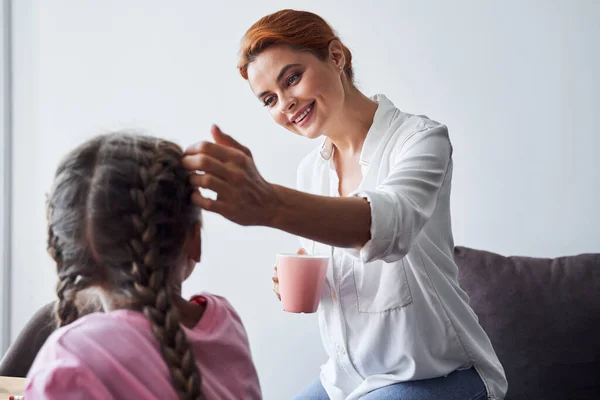 Mom with care stroking her daughters head