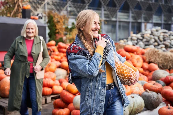 Mujer llevando bolsa de cuerda con calabaza —  Fotos de Stock