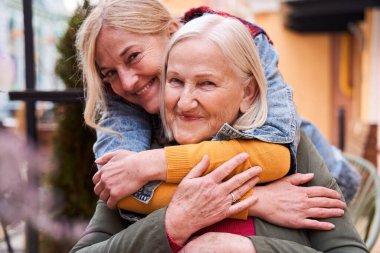 Kadın ve güzel sarışın kızı birbirlerini ematize ediyorlar.