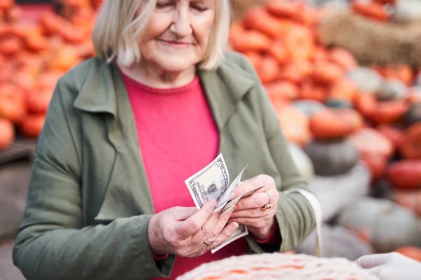 Женщина считает деньги, покупая что-то — стоковое фото