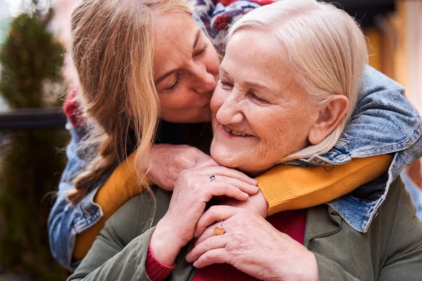 Femme embrassant sa mère âgée à la joue — Photo