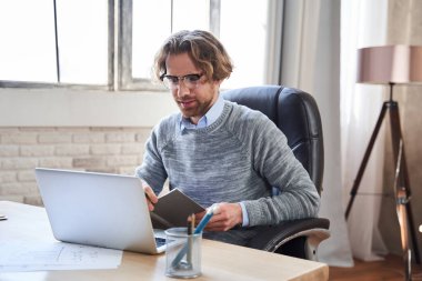 Gözlüklü adam rahat sandalyeye otur.