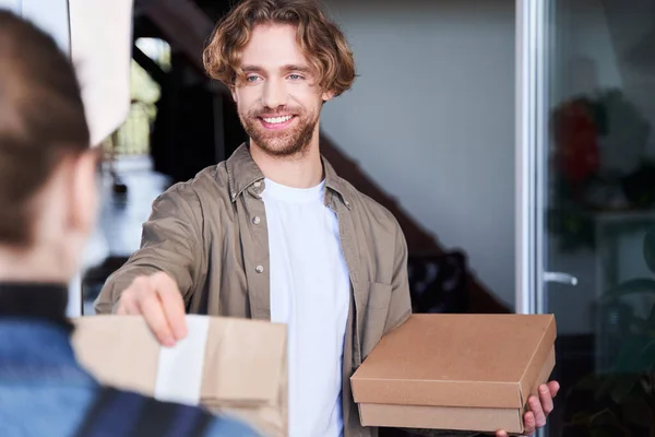 Kurir levererar matvaror order till unga män hem — Stockfoto