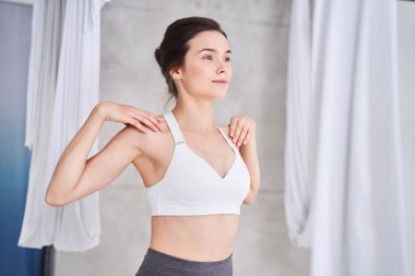 Kollarını ve omuzlarını açan bir kadın.