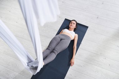 Spor kıyafetli kadın uçuş yogası yapıyor.