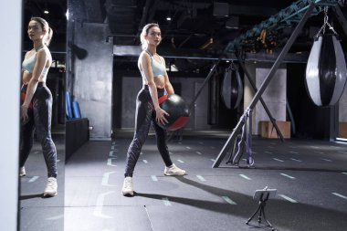 Spor elbiseli bir kadın vücut egzersizi yapıyor.