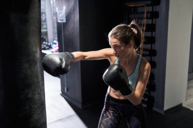 Spor salonunda kadın çantası tekmeliyor.