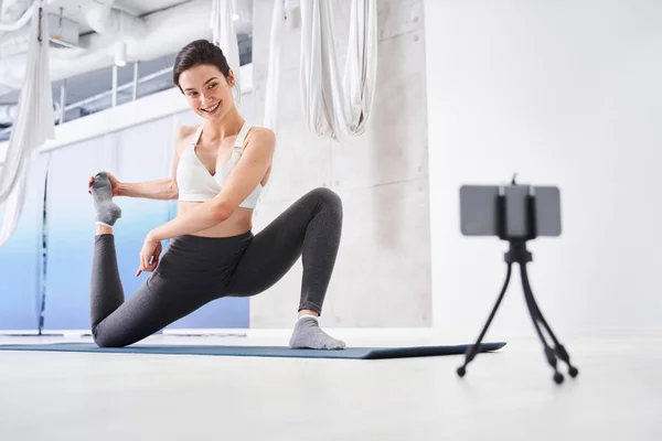 Mujer sosteniendo su pierna mientras estira — Foto de Stock