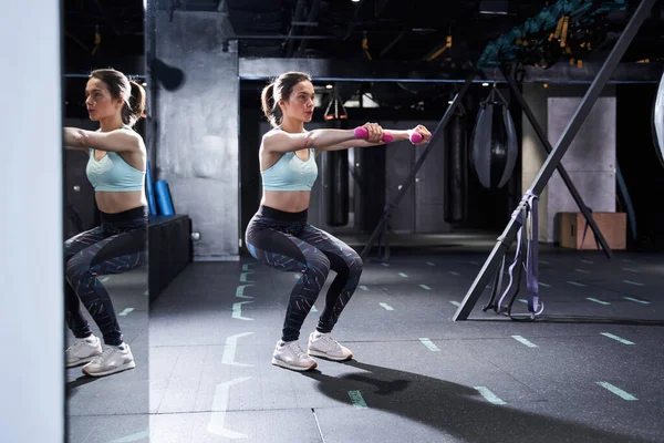 Mujer haciendo ejercicio con pesas en el gimnasio — Foto de Stock