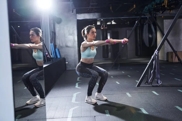 Mujer haciendo sentadillas con mancuernas — Foto de Stock