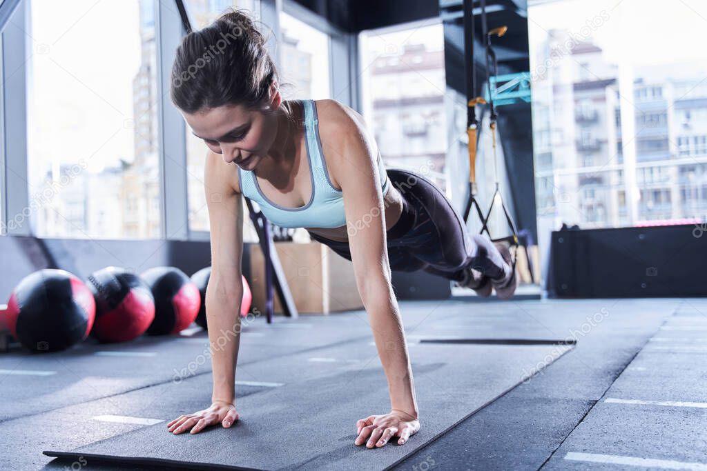 Woman training with trx fitness straps