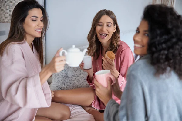 Κορίτσια με πιτζάμες πίνουν τσάι με κεκάκια — Φωτογραφία Αρχείου