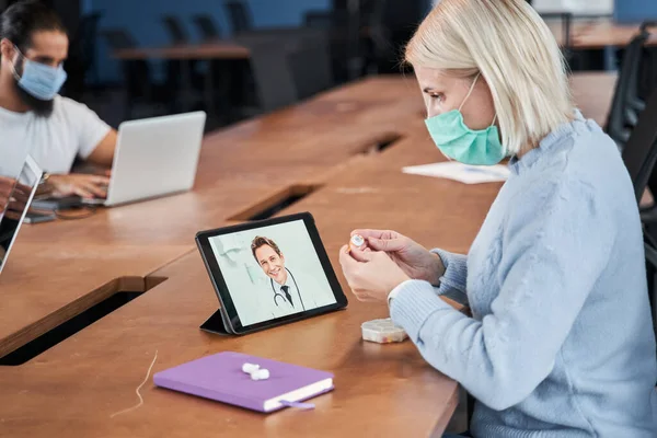 Woman wearing protective mask sitting at the office — Stock Photo, Image