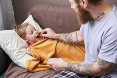 Baba hasta küçük kızına bakıyor.