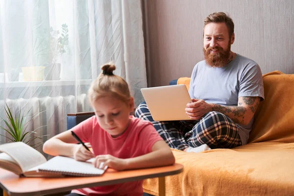 Flicka sitter vid skrivbordet och studerar hemma — Stockfoto