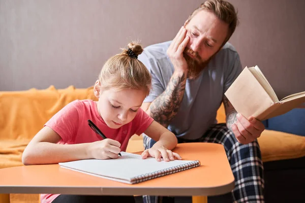 Pai ajudando a pequena filha com lição de casa — Fotografia de Stock
