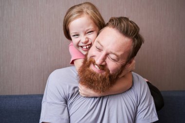 Baba küçük tatlı kızı kucaklıyor.