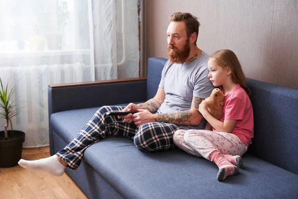 Padre y su hija preescolar viendo programa de televisión serio — Foto de Stock