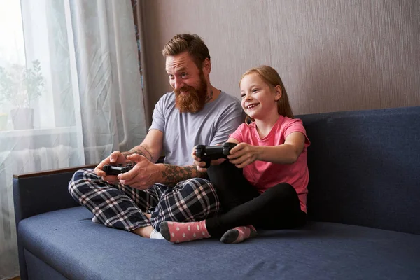 Ο πατέρας και η ξανθιά όμορφη κόρη του παίζουν βιντεοπαιχνίδια. — Φωτογραφία Αρχείου
