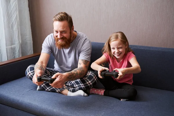Pai e sua pequena filha fofa com gamepads — Fotografia de Stock
