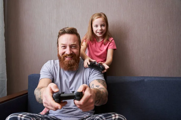 Father and his little cute daughter with gamepads