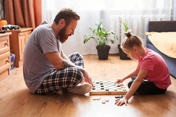 Father and his daughter playing checkers — Stock Photo, Image