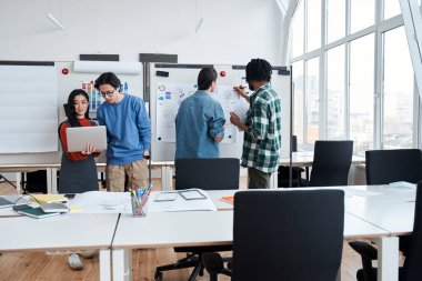 Bir grup üniversite öğrencisi bir şeyi tartışıyor ve bilgisayar ekranına bakıyor.